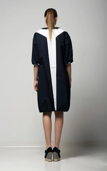 Bakifrån av trendiga chichi kvinna i vit-svart kontrast regnrock. Vogue — Stockfoto