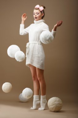 Falling Skeins. Surprised Woman in Woolen Knitted Jersey with White Balls of Yarn clipart