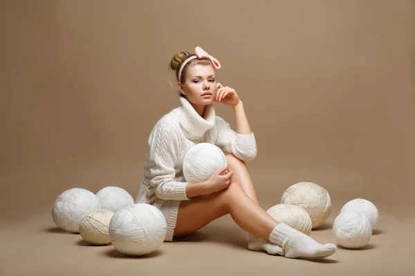 Trabajo doméstico. Mujer joven en Tricot blanco con bolas de lana. Costurera — Foto de Stock