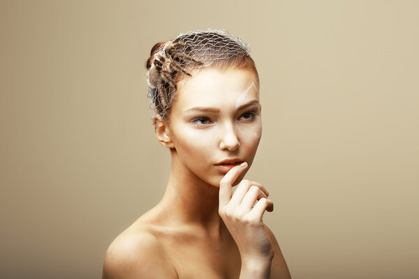 Fantasy. Creative Concept. Tarantula Spider on Woman's Head sitting in Metallic Cobweb