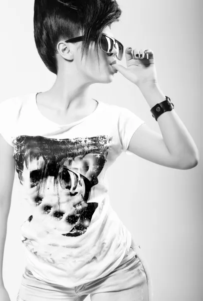 Speelse trendy vrouw in t-shirt en donkere zonnebrillen likken haar vinger. expressie — Stockfoto