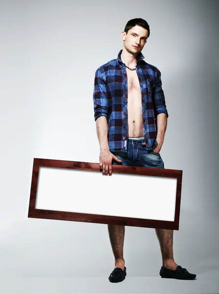 Junger Mann zeigt Plakat mit weißer Leerstelle — Stockfoto