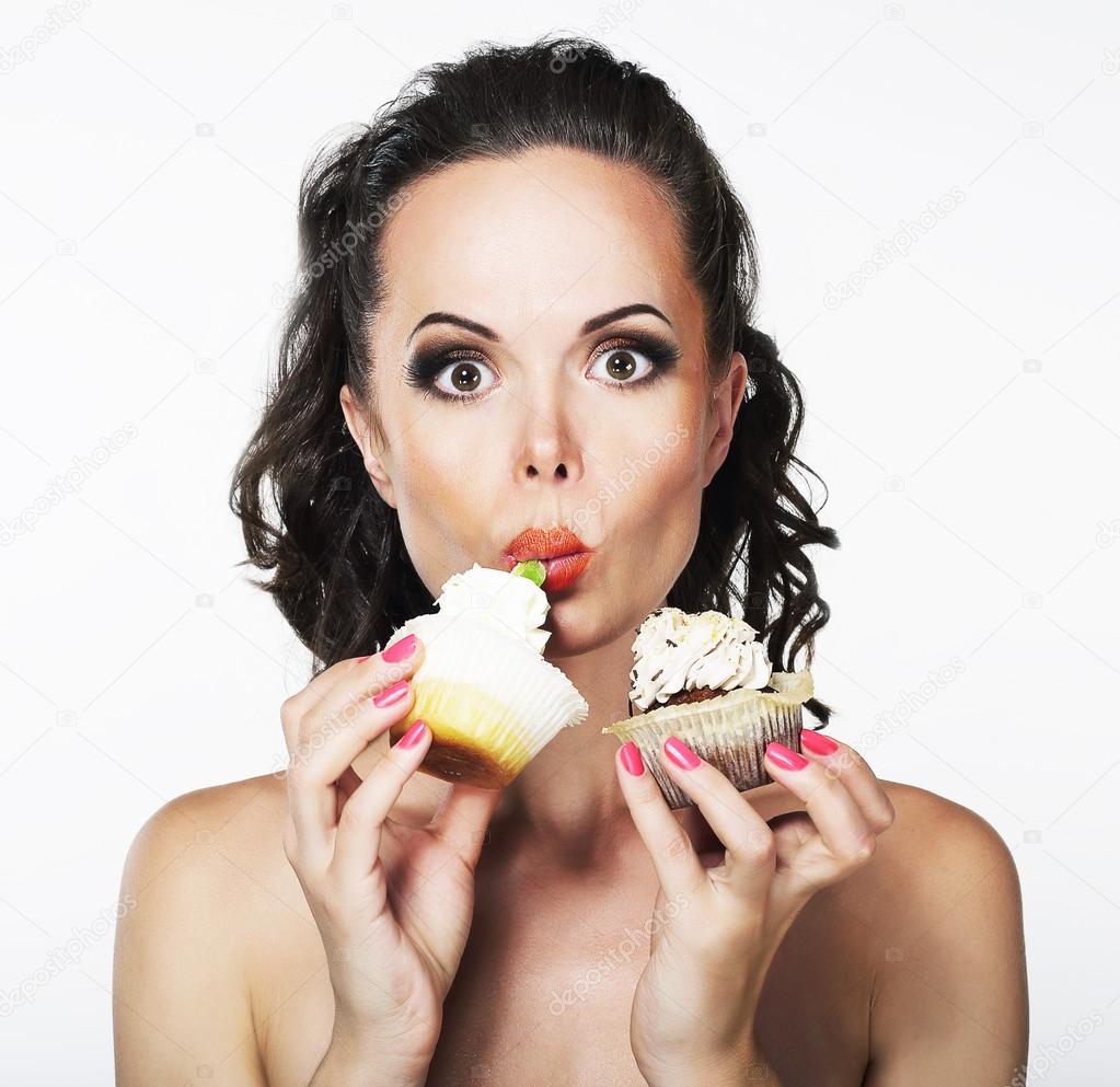 Gluttony. Hungry Funny Young Woman Greedily Eats Cakes with Cream