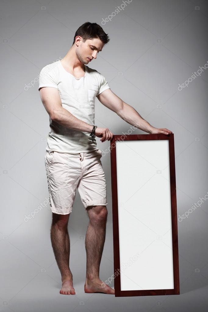 Shoeless Man Displaying White Board with Blank Space