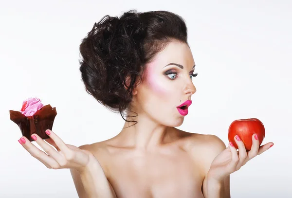 Sorprendida mujer divertida decide entre manzana y pastel — Foto de Stock