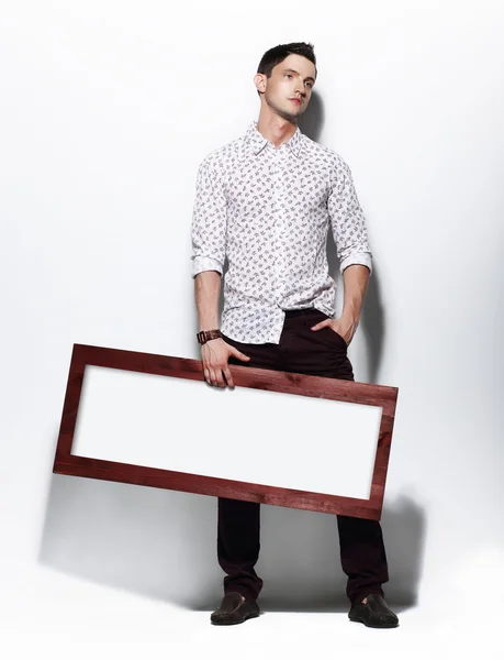 Hombre de moda sosteniendo tablero con blanco espacio en blanco para el texto — Foto de Stock