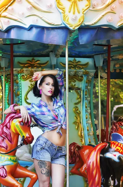 Merry-go-round. lekfull snygg prålig kvinna i rondellen. nöjesfält — Stockfoto