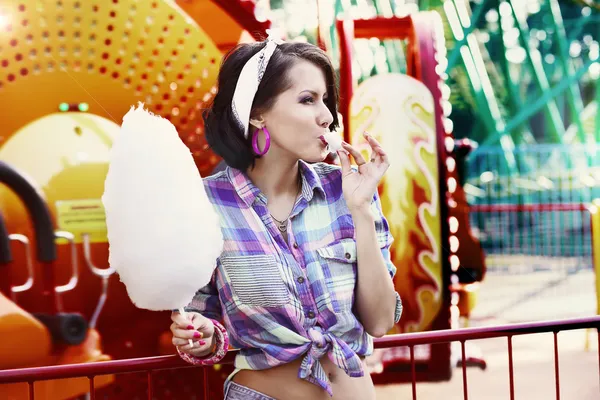 Jovem mulher americana no parque de diversões comer algodão doce — Fotografia de Stock