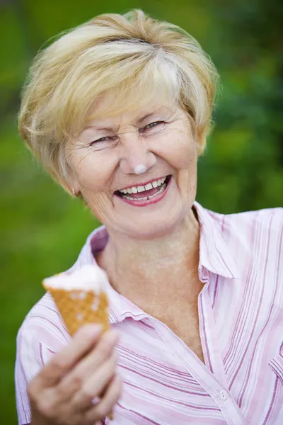 Удовлетворение. Ликующая экстатичная старуха с мороженым и смехом — стоковое фото