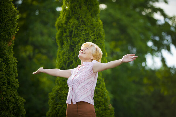 Lifestyle. Freedom. Excited Retired Old Woman with Outstretched Arms