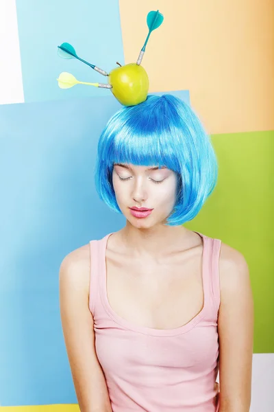 Brincadeira. Mulher excêntrica Oddball em Blue Wig com dardos e maçã verde — Fotografia de Stock