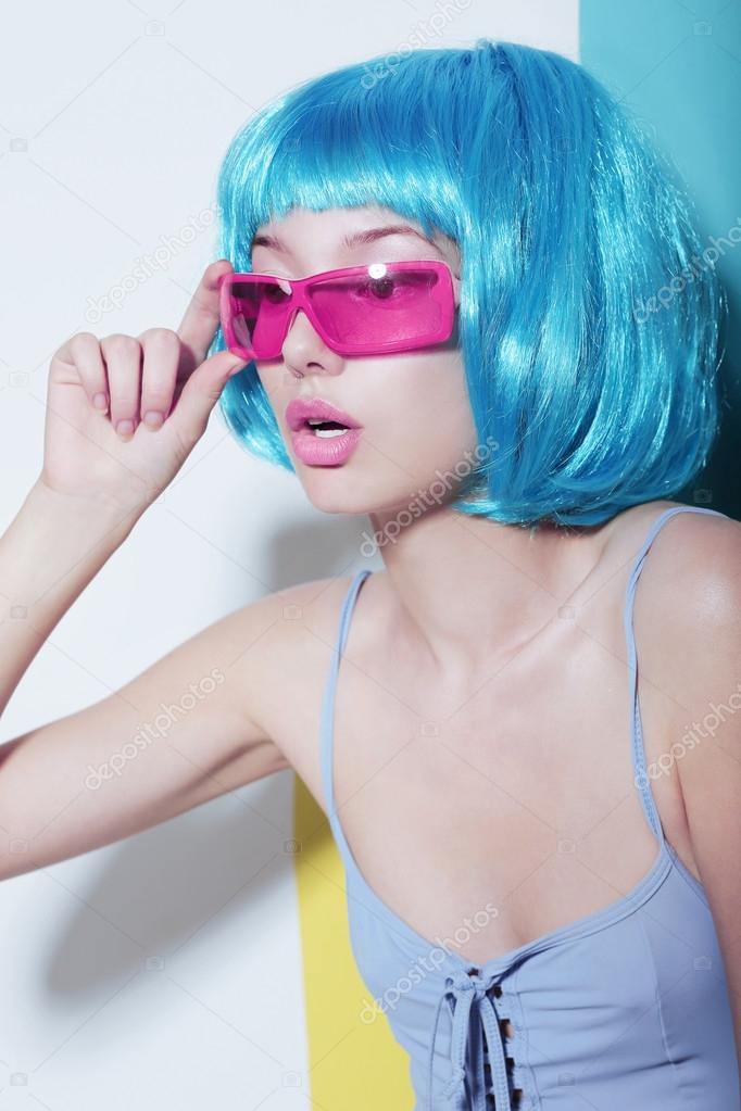 Individuality. Woman wears Blue Glossy Wig and Pink Glasses