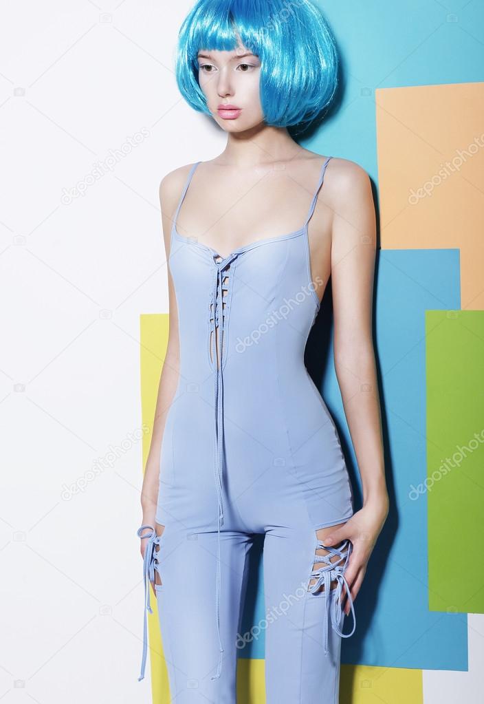 Vogue. Shapely Young Woman in Blue Overalls and Creative Wig posing