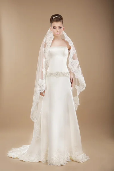 Fiatal menyasszony, csipkés esküvői ruha felső barna háttér — Stock Fotó
