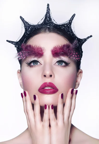Kreativa koncept. kvinna med fancy huvudbonader och röda make-up — Stockfoto