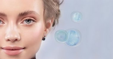 Bir kadının yüzüne yakın çekim. İlaç veya krem damlaları veya molekülleri hücreleri yeniler, onları besler ve vitaminlerle doldurur. Yüz bakımı.