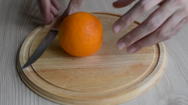 Резать апельсин на столе — стоковое видео