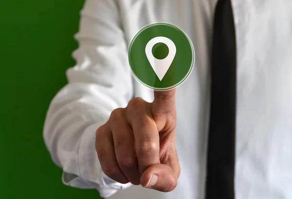 Businessman touching a virtual icon with a location marker symbol — Stock Photo, Image