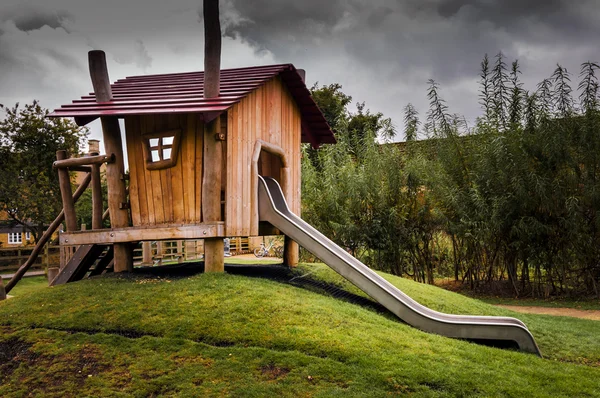 Maison de jeux pour enfants en bois avec toboggan — Photo