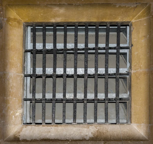 Metal grilled window set in stone work — Stock Photo, Image
