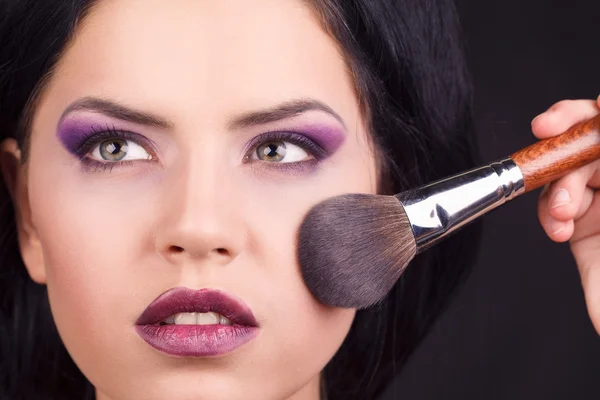 Portrait of the beautiful woman with makeup brushes near face — Stock Photo, Image