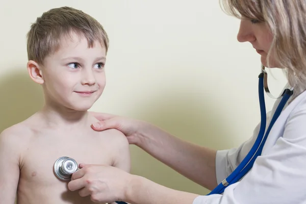 Jovem e bonito médico visitando com um estetoscópio um littl — Fotografia de Stock