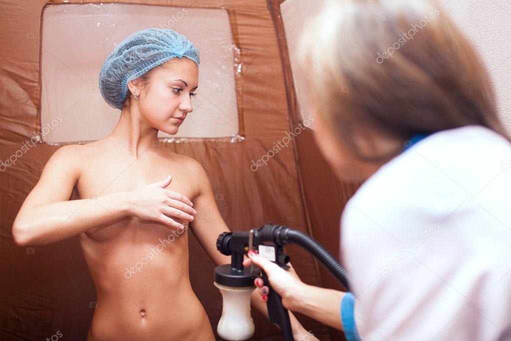 Young attractive brunette girl on the tanning process