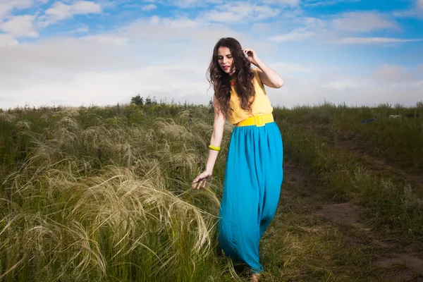 Beautiful young girl with long hair in field — Stock Photo, Image