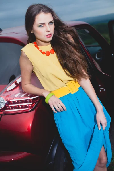 站在红色的车旁边的年轻黑发女人 — 图库照片
