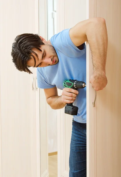 Homem reparando a porta alça móveis — Fotografia de Stock