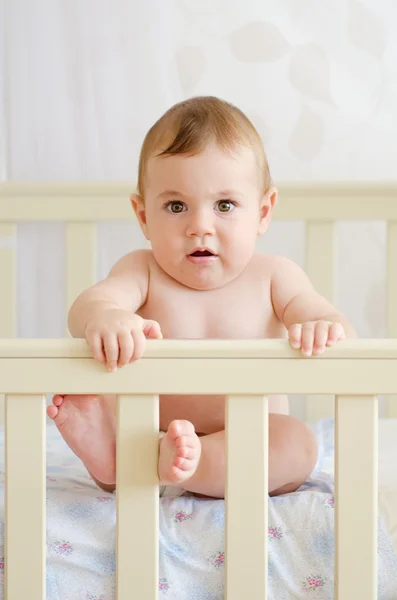 Baby sitting in a crib — Stock Photo, Image