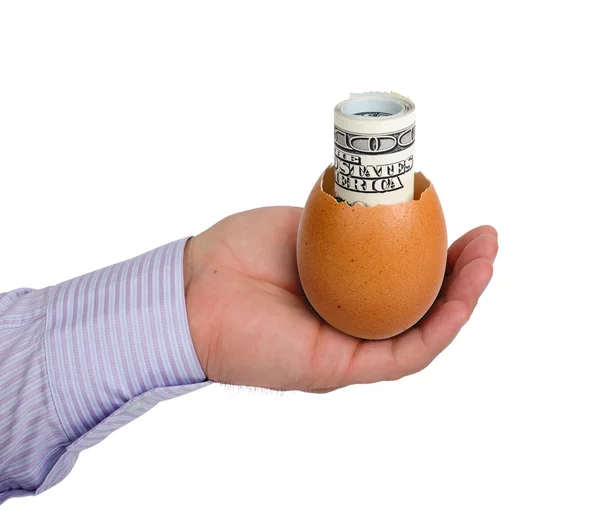 Яйцо с деньгами в руке — стоковое фото