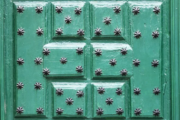 Πράσινη πόρτα με στολίδια με τη μορφή μαύρο αστέρι, φόντο — Φωτογραφία Αρχείου