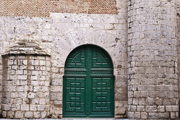 Groene deur in een stenen muur — Stockfoto