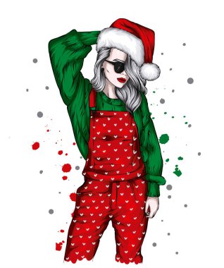 Noel şapkalı ve şık elbiseli güzel bir kız. Moda, tarz, giysi ve aksesuarlar. Yeni Yıl ve Noel. 