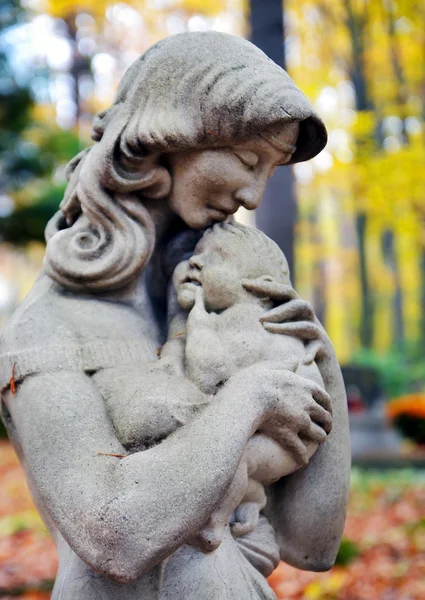 Standbeeld van madonna en kind in herfst bos — Stockfoto