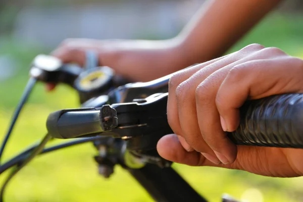 Mãos segurando o guidão na bicicleta — Fotografia de Stock