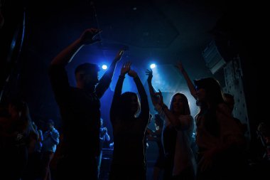 Enerjik kalabalık. Gece kulübünde güzel ışıklandırmalarla dans etmeyi seven bir grup insan..