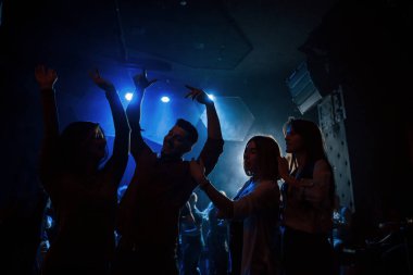 Mutlu gençlik. Gece kulübünde güzel ışıklandırmalarla dans etmeyi seven bir grup insan..