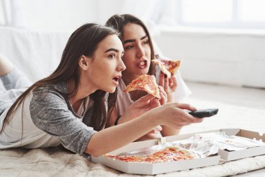 İmkanı yok, gördün mü? Gündüz vakti güzel yatak odasının zemininde yatarken TV izlerken pizza yiyen rahibeler..