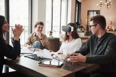 Sanal gerçeklik gözlükleriyle ilk deneyimim. Ofis odasında eğleniyorum. Dost canlısı iş arkadaşları ara verdiklerinde etrafta oynuyorlar..