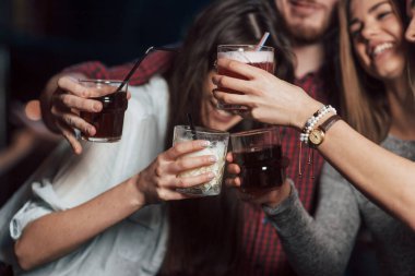 Alkollü parti. Gece kulübünde gülümseyen ve kadeh kaldıran bir grup genç arkadaş..