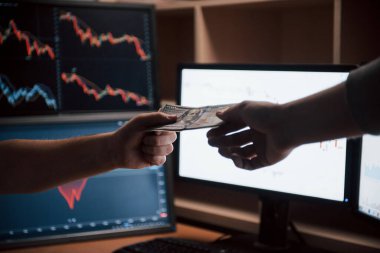 Yan görüş. Modern ofiste üzerinde ekranlar ve grafikler olan maaş günü.