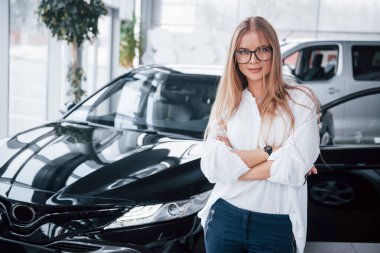 Tamirhanedeki genç müdür mükemmel cilalanmış siyah arabaya karşı duruyor..