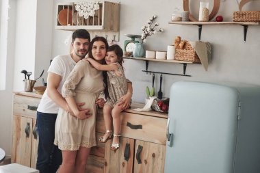 Hamile anne, baba ve kızlarının şirin bir aile fotoğrafı. Tktchen 'de dikilirken.
