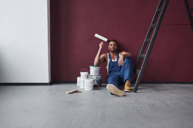 Boş zamanın tadını çıkarıyorum. Mavi üniformalı genç Afro-Amerikan işçilerinin yapacak işleri var..