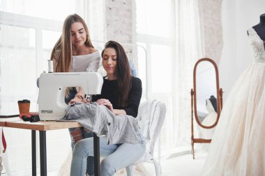 Sakin ol. İki kadın moda tasarımcısı atölyedeki yeni kıyafetler üzerinde çalışıyor..