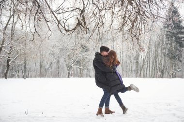 İnsanoğlunun ellerinde. Göz kamaştırıcı genç çift, karlı ormanda birlikte iyi vakit geçiriyor..