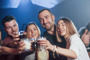 - Boş zaman. Lüks gece kulübünde ellerinde farklı içkilerle dans eden mutlu insanlar..