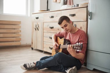 Odada yalnızdım. Müzisyen hafta sonu evde, mutfakta akustik gitar çalar..